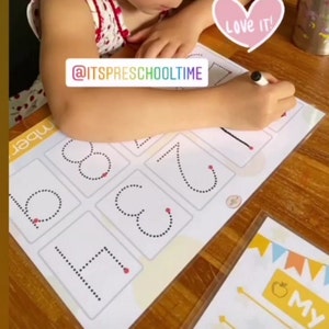 May include: A child traces the numbers 1 through 8 on a white worksheet with a black marker. The worksheet has a yellow background with a dotted line for each number. The text "@ITSPRESCHOOLTIME" is written on the worksheet. A pink heart with the text "Love it!" is in the upper right corner of the image.