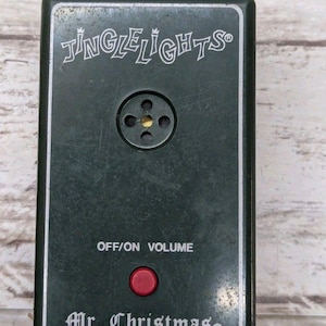 May include: A dark green "Jingle Lights" sound module with a red button and the text "OFF/ON VOLUME". The module is labeled "Mr. Christmas" and has a plug for an electrical outlet.