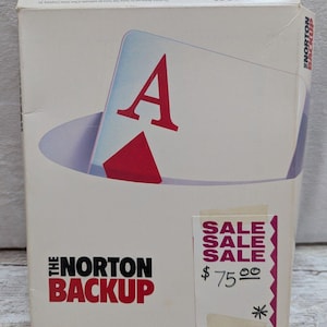 May include: A white box for "The Norton Backup" software. The box features a playing card design with a large red "A". A "SALE" sticker with a price of $75 is affixed to the box.