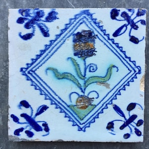 Antique Dutch Delft tile with a tulip in diamond