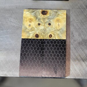 May include: Two wooden blanks with a black and white honeycomb pattern. The wood has a light brown and yellow color with dark brown swirls.