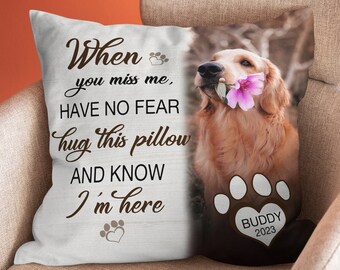 May include: White pillow with a brown paw print and the text "When you miss me, HAVE NO FEAR hug this pillow AND KNOW I'm here" and a photo of a golden retriever with a pink flower in its mouth. The paw print has the text "BUDDY 2023" inside.