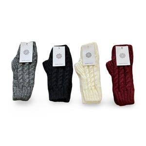 May include: Four pairs of fingerless knit gloves in different colors: gray, black, white, and burgundy. The gloves have a cable knit pattern and are made of wool.
