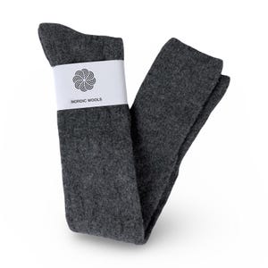 May include: A pair of gray knee-high socks with a white label that reads "Nordic Wools" and a stylized flower logo.