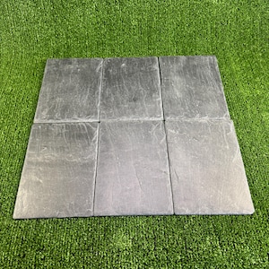 May include: Six black slate tiles arranged in a rectangular pattern. The tiles are smooth and have a slightly textured surface.