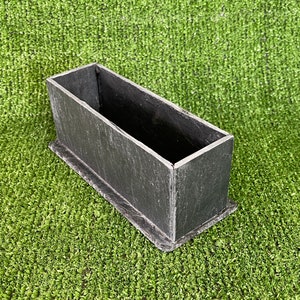 May include: A rectangular black slate planter with a rough, textured surface. The planter is empty and ready for planting.
