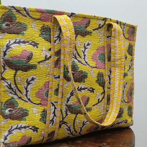 Bolsa de compras acolchada con estampado de bloques hecha a mano y bolsillo interior. Bolsa de compras grande de algodón con estampado floral en amarillo y rosa.