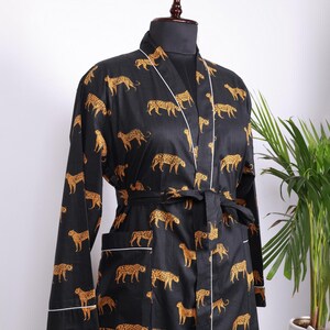 May include: Black and gold leopard print robe with white piping trim and a matching tie belt.