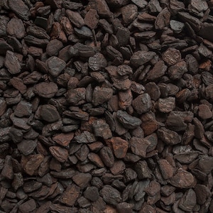 May include: Close-up of a pile of dark brown charcoal pieces. The charcoal is irregularly shaped and has a rough texture.