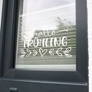 K&ouml;nnte beinhalten: Ein Fenster mit einem wei&szlig;en Vinyl-Aufkleber, auf dem "hallo fr&uuml;hling" mit einem Herzen und Bl&auml;ttern steht.