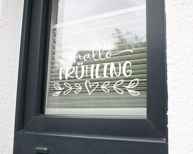 K&ouml;nnte beinhalten: Ein Fenster mit einem wei&szlig;en Vinyl-Aufkleber, auf dem "hallo fr&uuml;hling" mit einem Herzen und Bl&auml;ttern steht.