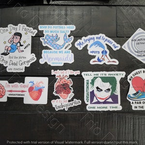 May include: A collection of nine stickers with various designs and text. The stickers feature a mermaid, a heart, a brain, a cartoon character, the Joker, a pair of shoes, and a heart with a heartbeat line. The stickers are in a variety of colours, including blue, green, red, and white.