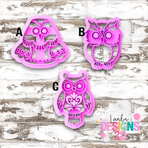 Peut inclure: Trois emporte-pièces en plastique rose vif en forme de hiboux, étiquetés A, B et C. L'emporte-pièce A présente un hibou large aux ailes à motifs, B montre un hibou classique aux grands yeux, et C affiche un hibou au motif décoratif sur le torse.