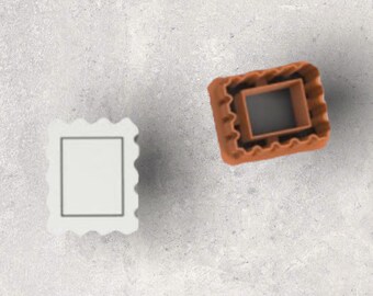 Può includere: Due formine per biscotti a forma di francobollo. Uno è bianco con un centro quadrato e un bordo smerlato. L'altro è marrone con un centro quadrato e un bordo smerlato. Le formine sono di plastica e su una superficie grigia.