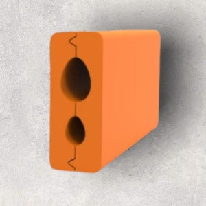 May include: Orange rectangular object with two oval holes. The object has a smooth surface and is set against a grey background. The top and bottom edges have a zig-zag design.