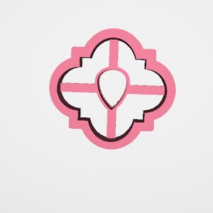 May include: A pink cookie cutter in a quatrefoil shape with a teardrop in the center. The cutter has a distressed, brushstroke-like texture, and is set against a white background.