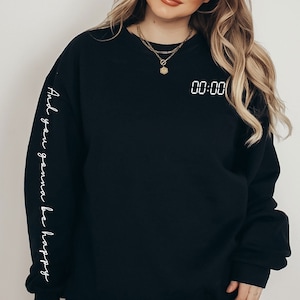 May include: Black sweatshirt with white text on the sleeve that reads "And you gonna be happy" and white text on the front that reads "00:00".