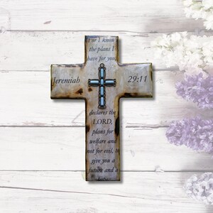 May include: A rustic wooden cross with a light blue and silver cross design and the text "Jeremiah 29:11" and the quote "For I know the plans I have for you, declares the LORD, plans for welfare and not for evil, to give you a future and a hope"
