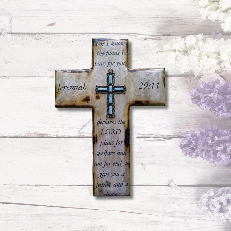 May include: A rustic wooden cross with a light blue and silver cross design and the text "Jeremiah 29:11" and the quote "For I know the plans I have for you, declares the LORD, plans for welfare and not for evil, to give you a future and a hope"