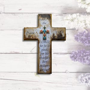 May include: A rustic wooden cross with a white background and a colorful mosaic design. The cross features the text "Psalm 118-1" and the words "Oh, give thanks to the LORD, for he is good, for his steadfast love endures forever!"