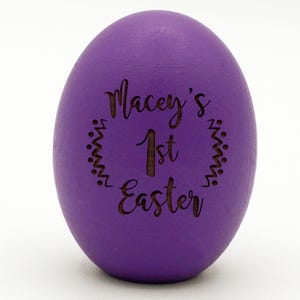 May include: Purple Easter egg with the text "Macey's 1st Easter" engraved on it.