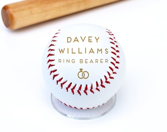 May include: White baseball with red stitching and the text "Davey Williams Ring Bearer" in gold lettering. Two gold rings are below the text.