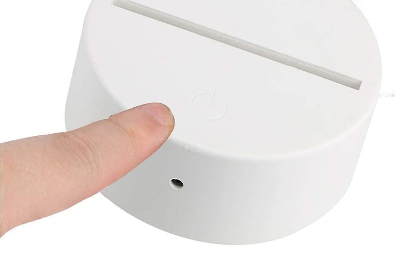 May include: White round base with a thin, white light strip on top. The base has a small, round power button on the side.