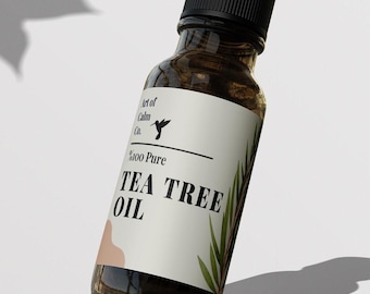 May include: A brown glass bottle with a white label that says "100% Pure Tea Tree Oil" and a hummingbird logo. The label also says "Art of Cabin Co."