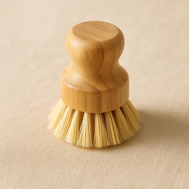Puede incluir: Un cepillo redondo para lavar platos de bamb&uacute; natural con un cabezal de cerdas de color claro. El cepillo presenta un mango redondeado para un f&aacute;cil agarre y un dise&ntilde;o compacto. Las cerdas son de color beige claro y el mango es de color marr&oacute;n claro.