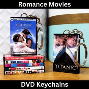 May include: A collection of DVD keychain charms featuring popular romance movies, including "The Notebook", "A Walk to Remember", "Never Been Kissed", "Legally Blonde", "13 Going on 30", "Dear John", and "Titanic".