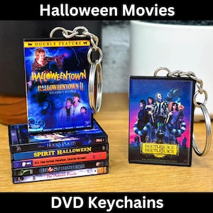 Puede incluir: Un conjunto de seis llaveros de DVD con películas populares de Halloween. Los abalorios son negros con imágenes coloridas de las películas. Los abalorios están unidos a llaveros plateados. Las películas que aparecen son: "Halloweentown", "Hocus Pocus", "Spirit Halloween", "Es la Gran Calabaza, Charlie Brown", "Ghostbusters" y "Beetlejuice".
