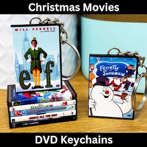 May include: Two Christmas movie DVD keychains. One features Will Ferrell as Buddy the Elf from the film Elf. The other features Frosty the Snowman from the film Frosty the Snowman.
