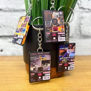 May include: Four miniature video game cases on keychains. The cases are for the games "The Legend of Zelda: The Wind Waker", "The Legend of Zelda: Twilight Princess", "The Future of Archon", and "Become a Legend".