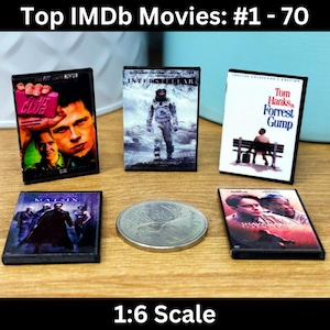 May include: Five miniature DVD cases featuring popular movies. The cases are arranged in two rows. The top row features "Interstellar", "Forrest Gump", and "The Usual Suspects". The bottom row features "The Matrix" and "The Godfather". The cases are all 1:6 scale.