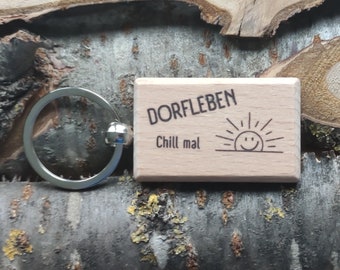 Handgefertigter Schlüsselanhänger "Dorfleben - Chill mal" aus Holz mit Schlüsselring. Verschiedene kleine Zusatz-Anhänger wählbar.