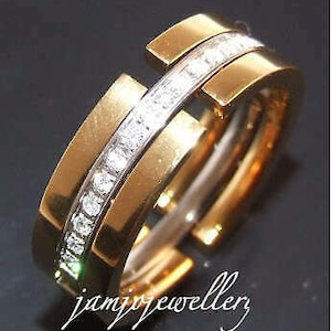 May include: A gold ring with a band of diamonds set in a channel setting. The ring is made of two pieces that fit together.