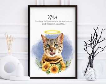 May include: A framed print with a watercolor painting of a tabby cat with a halo above its head. The cat is surrounded by sunflowers and greenery. The text "Nala" and "You have left paw prints on our hearts that will last a lifetime" is printed below the image.