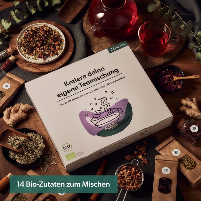 May include: A white box with the text "Kreiere deine eigene Teemischung" and "Mische dir deinen Tee aus 14 hochwertigen Teekomponenten". The box is surrounded by various tea ingredients, including dried flowers, herbs, and spices. The box is labeled "Bonates" and features a green and purple illustration of a teacup.