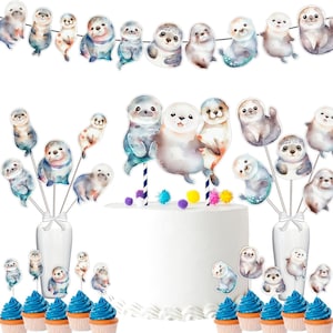May include: A set of watercolour seal cake toppers with a banner featuring seals in various poses. The toppers are perfect for a baby shower or birthday party.