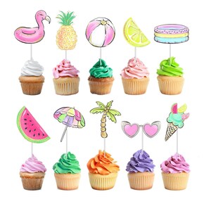May include: A collection of cupcakes with summer-themed toppers, including a flamingo, pineapple, beach ball, lemon slice, and pool float. The cupcakes have various frosting colors, such as white, pink, green, and orange. The toppers are attached to the cupcakes with thin silver sticks.