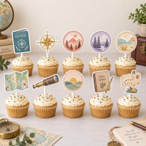 May include: A set of ten cupcakes topped with travel-themed paper decorations including a passport, compass, mountains, forest, beach, map, telescope, sun, travel journal with a pencil, and a wooden signpost with a red location pin icon.
