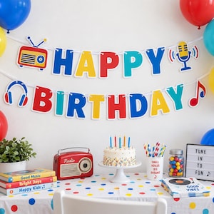 May include: A birthday party decoration set featuring a banner with the text HAPPY BIRTHDAY, a red radio, a white cake with candles, a cup with striped straws, a jar of colourful gumballs, a sign reading TUNE IN TO FUN, and a stack of books.