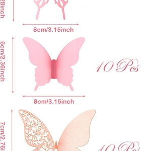 May include: A set of 10 pink and gold butterfly wall decorations. The butterflies are 5.8 cm, 6 cm, and 7 cm in size. The butterflies are made of paper and have a delicate, intricate design.