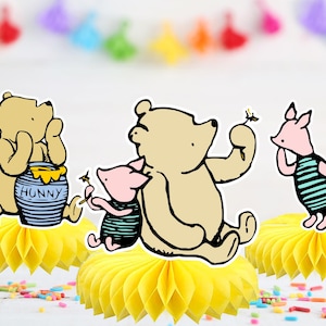 May include: Three Winnie the Pooh characters, Winnie the Pooh, Piglet and Eeyore, are depicted in a cartoon style. Winnie the Pooh is holding a jar of honey that says "Hunny". Piglet is holding a dandelion. Eeyore is standing on a yellow honeycomb-shaped paper decoration.