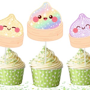 May include: Three cupcake toppers featuring cartoon dumplings in bamboo steamers. The dumplings are yellow, rainbow-colored, and purple with glittery textures and smiling faces. Each topper is mounted on a white stick inserted into a cupcake.