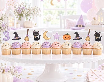 May include: A set of eleven cupcakes arranged on a white pedestal stand, each topped with a decorative paper topper featuring a purple number three, witch hats, brooms, black cats, a crescent moon, a star, and a pumpkin with a face.