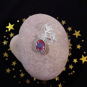 Silver Coloured DOUBLE SIDED Oval Pendant With a White/Blue Metallic AND a Red/Blue Metallic Acrylic Paint Poured Cabachon Centres