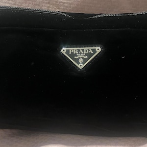 Pochette noire en velours Prada avec fermeture éclair, plaque logo triangulaire