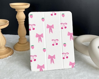May include: A white iPad case with a pink and white pattern of strawberries, cherries, and bows.