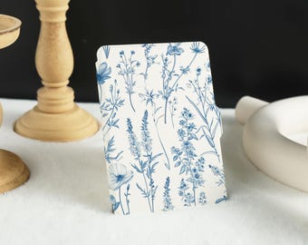 May include: A white book cover with a blue floral pattern. The flowers are stylized and have a vintage look.